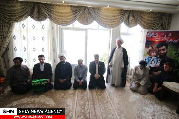 تصاویر حضور خادمان کریمه با پرچم حرم حضرت معصومه(س) در منزل شهید حججی