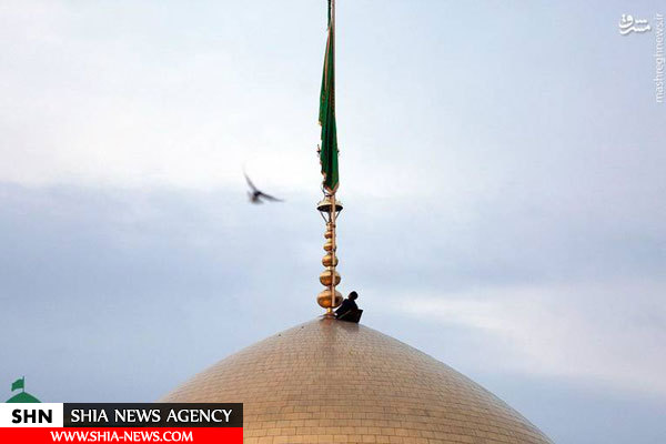 تصویر تعویض پرچم گنبد امام رضا(ع)