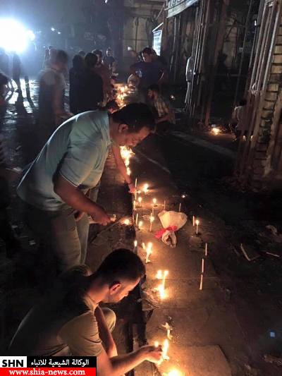 بالصور؛ العراقيون يشعلون الشموع بدموعهم في موقع تفجير الكرادة
