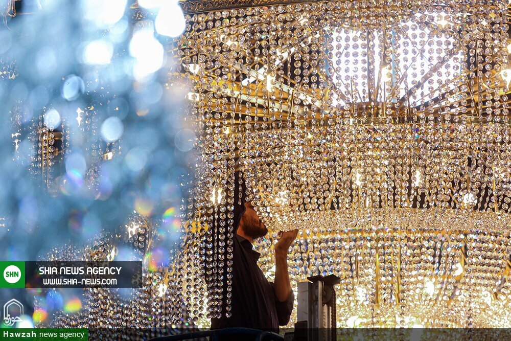 تصاویر/ غبارروبی بزرگترین لوستر حرم حضرت معصومه(س)