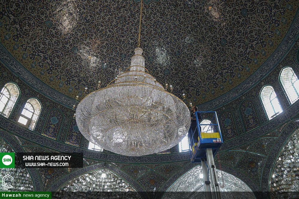 تصاویر/ غبارروبی بزرگترین لوستر حرم حضرت معصومه(س)