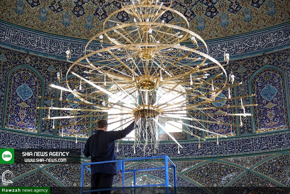 تصاویر/ غبارروبی بزرگترین لوستر حرم حضرت معصومه(س)