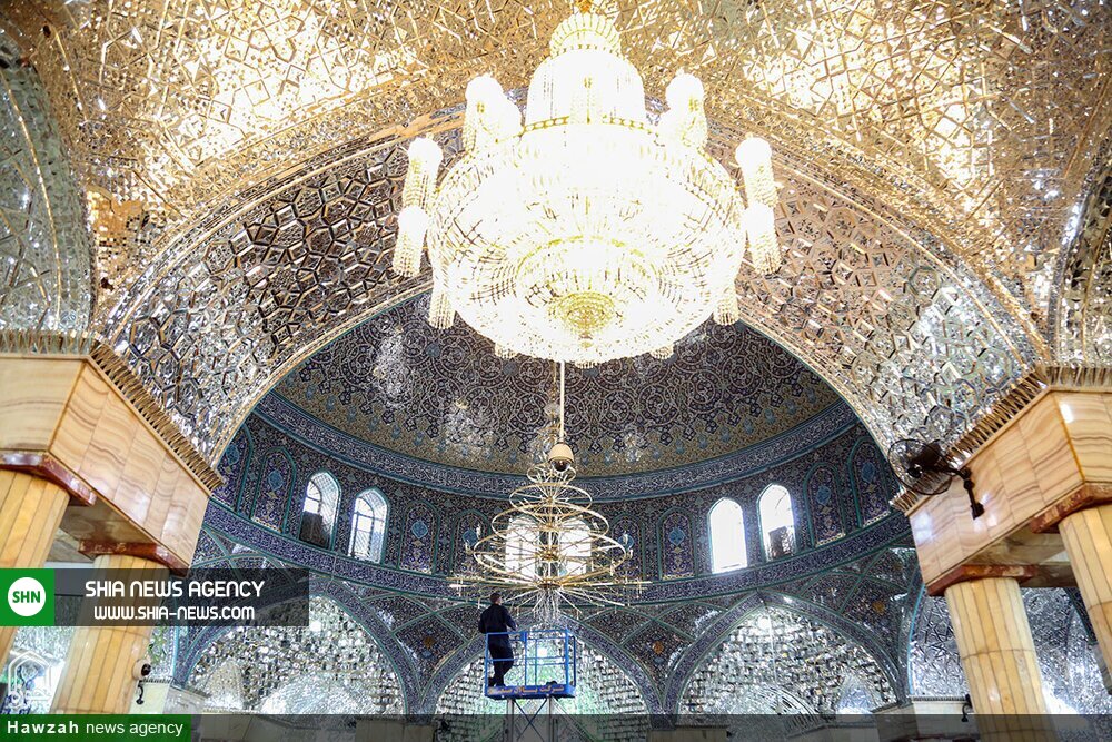 تصاویر/ غبارروبی بزرگترین لوستر حرم حضرت معصومه(س)