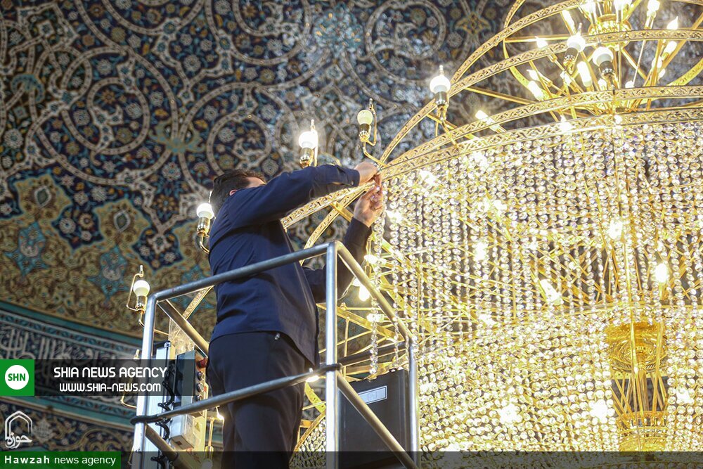 تصاویر/ غبارروبی بزرگترین لوستر حرم حضرت معصومه(س)