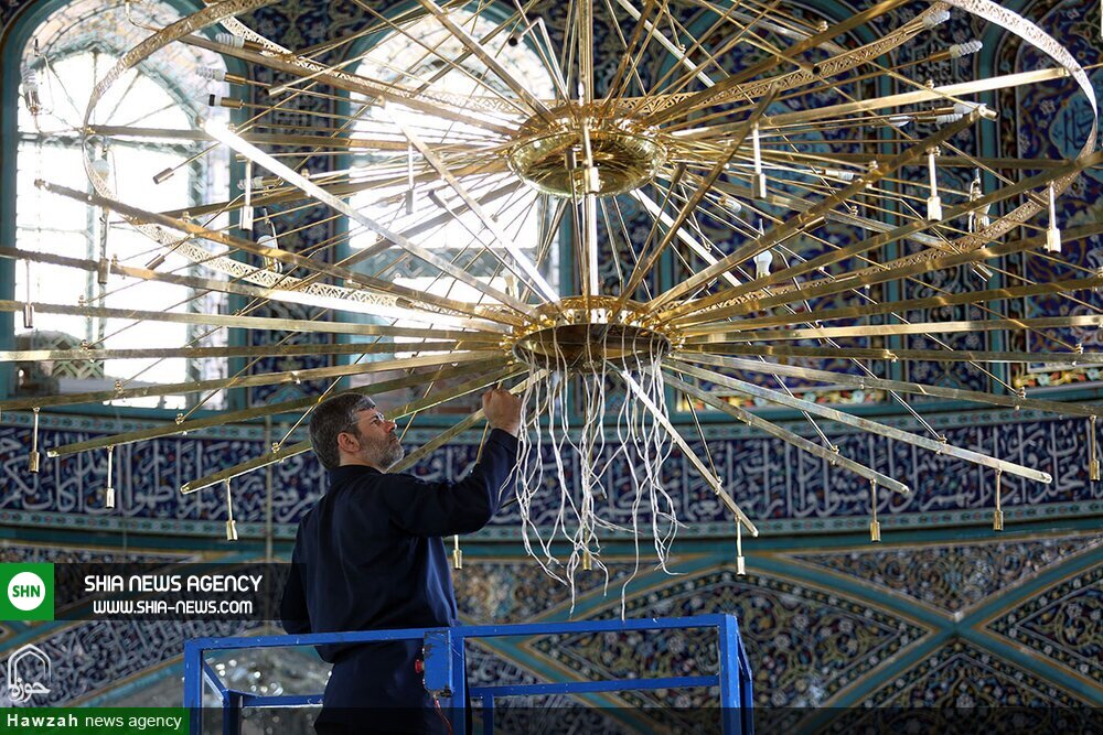 تصاویر/ غبارروبی بزرگترین لوستر حرم حضرت معصومه(س)